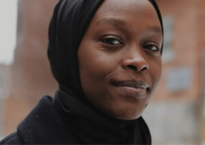 Woman facing the camera smiling.