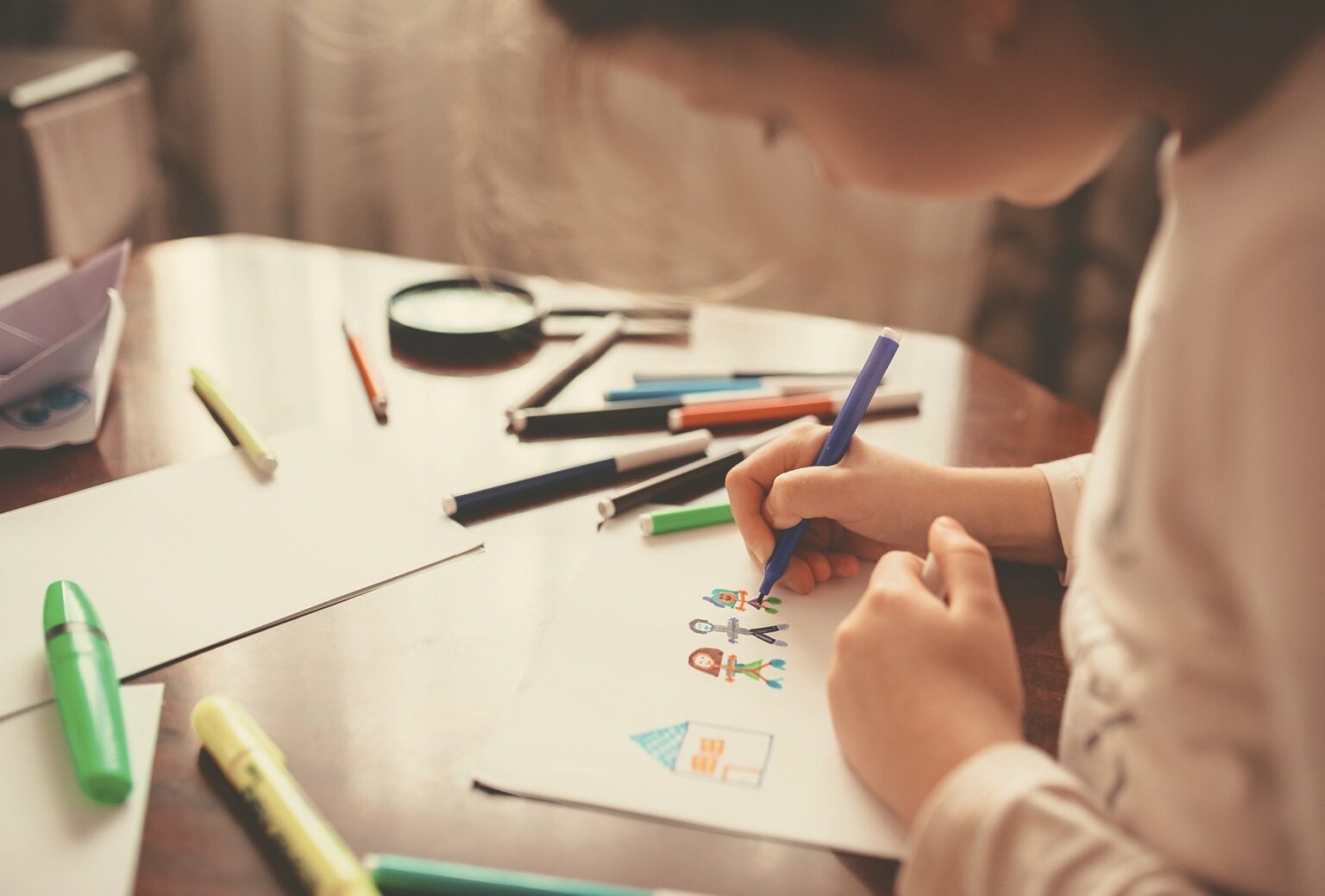 A child is drawing at a table.